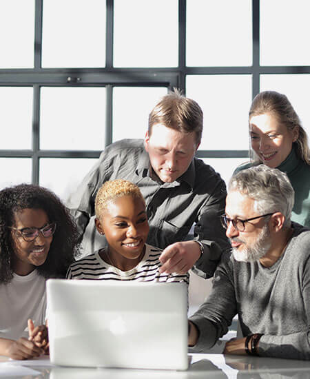 A group of learners looking at one laptop together